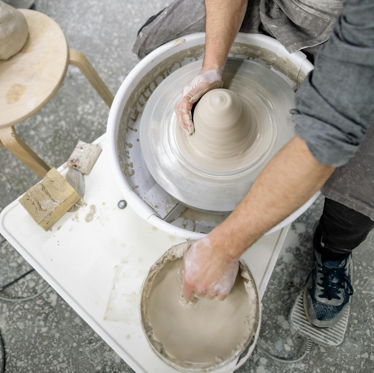 a potter centers clay at Claya pottery studio in River North Arts District in Denver, Colorado.