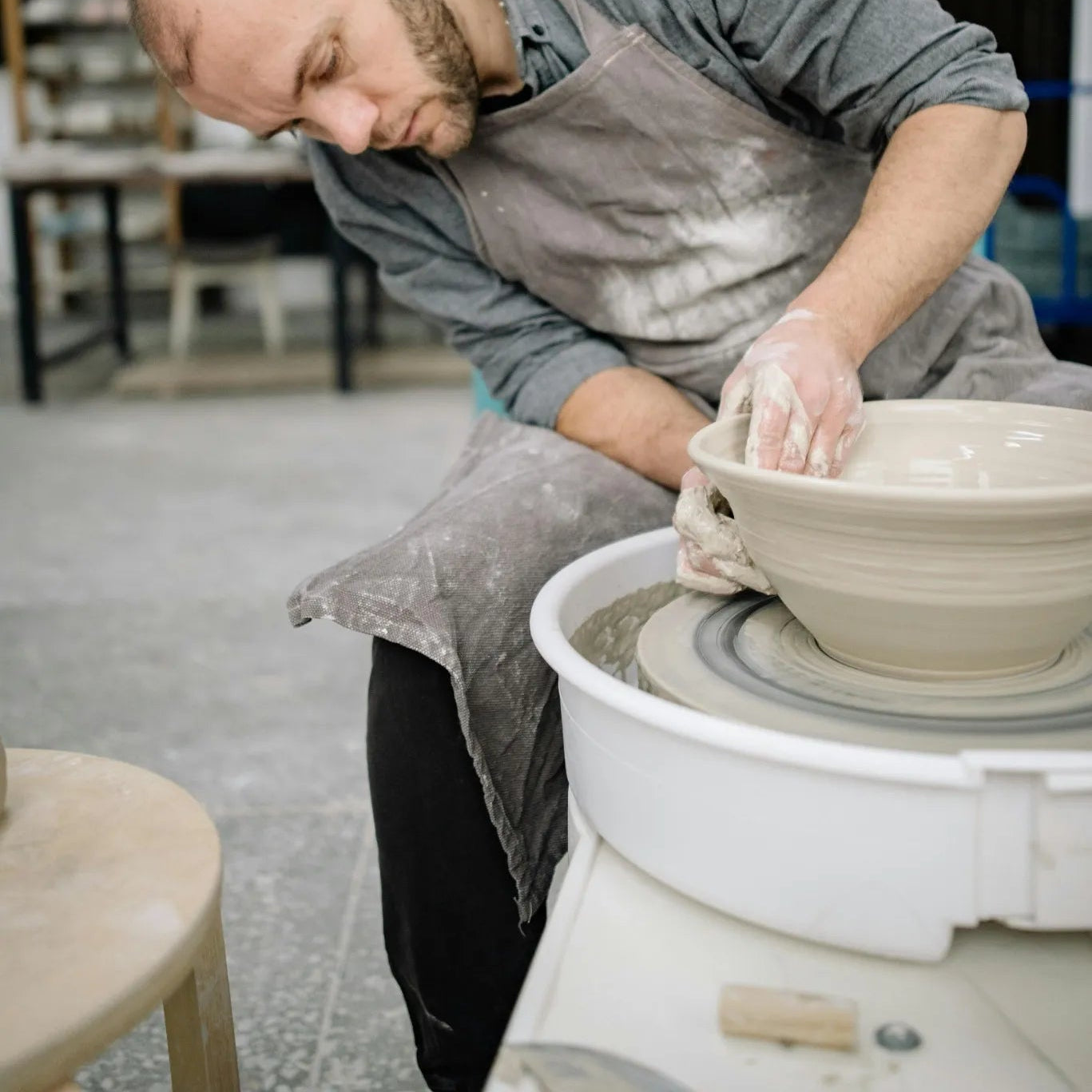 Potter at a pottery studio denver working on a pottery wheel in a studio at Denver Pottery Studio