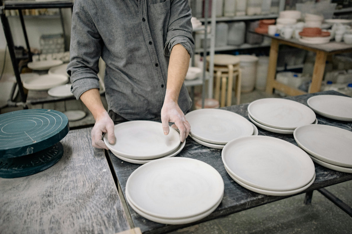 Finished handbuilt pottery pieces stacked at Claya pottery studio in Denver's RiNo district