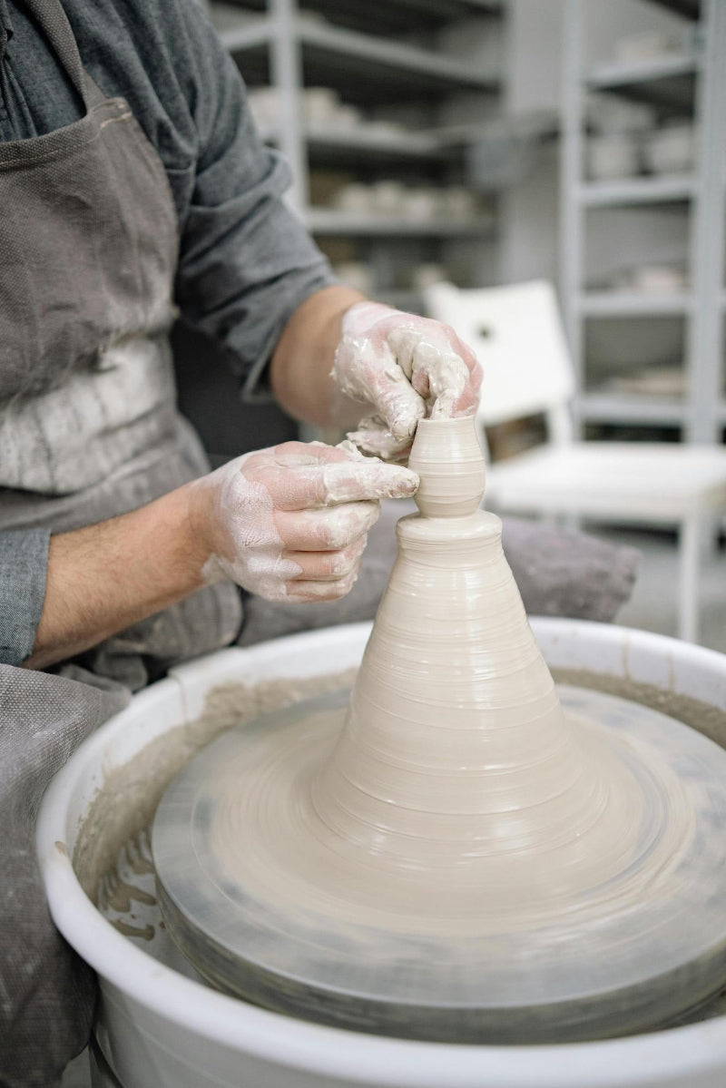 a potter throws a vase at claya pottery studio in denver