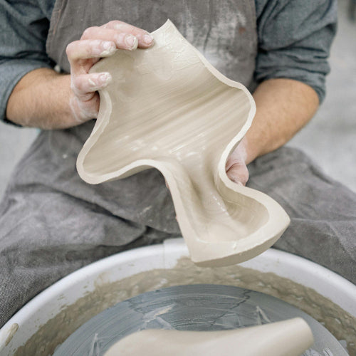 Person holding a ceramic bowl in a pottery studio at Claya studio in Denver, Colorado