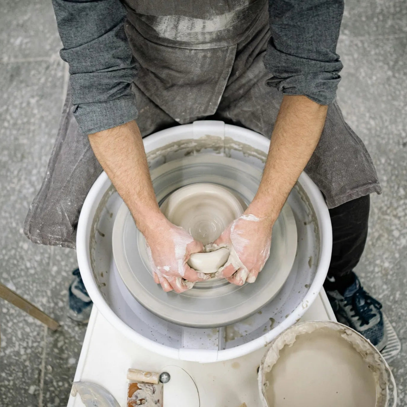 Potter working with clay on a pottery wheel in a pottery studio Denver