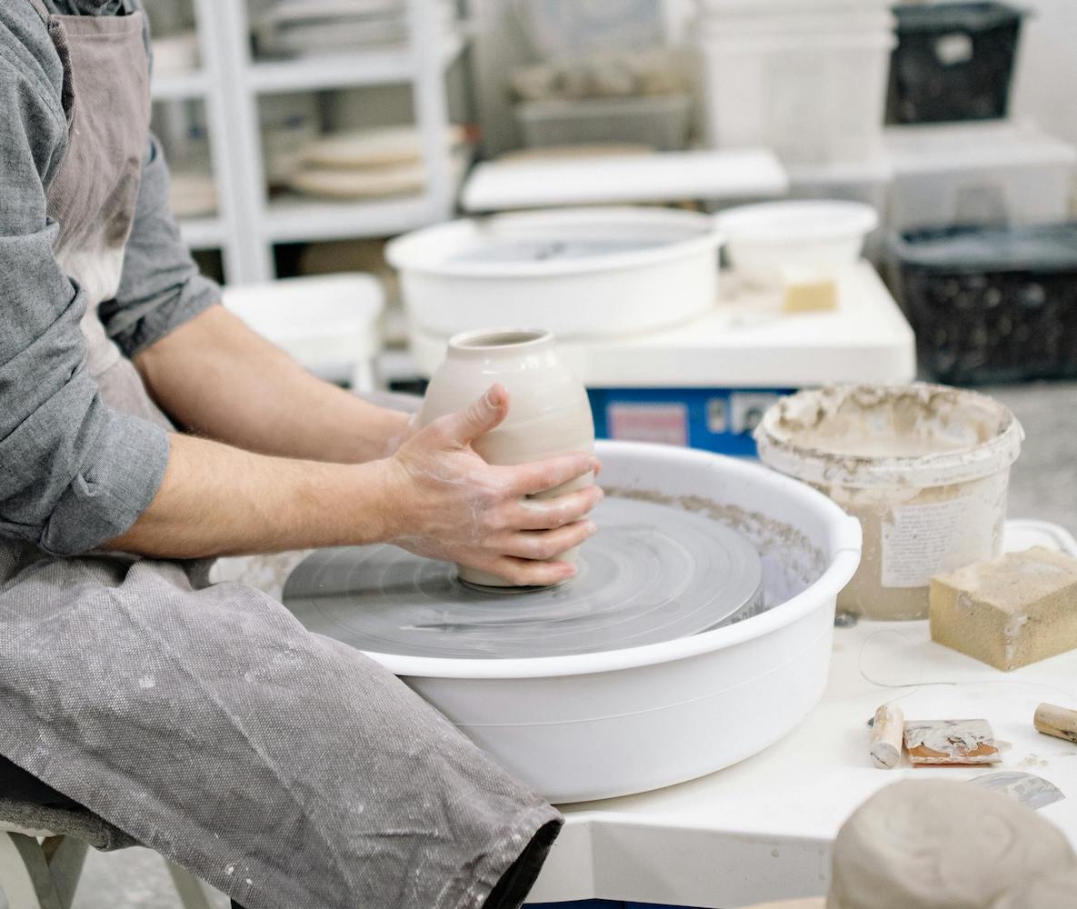 a potter places clay on a pottery wheel at Claya pottery studio in Denver
