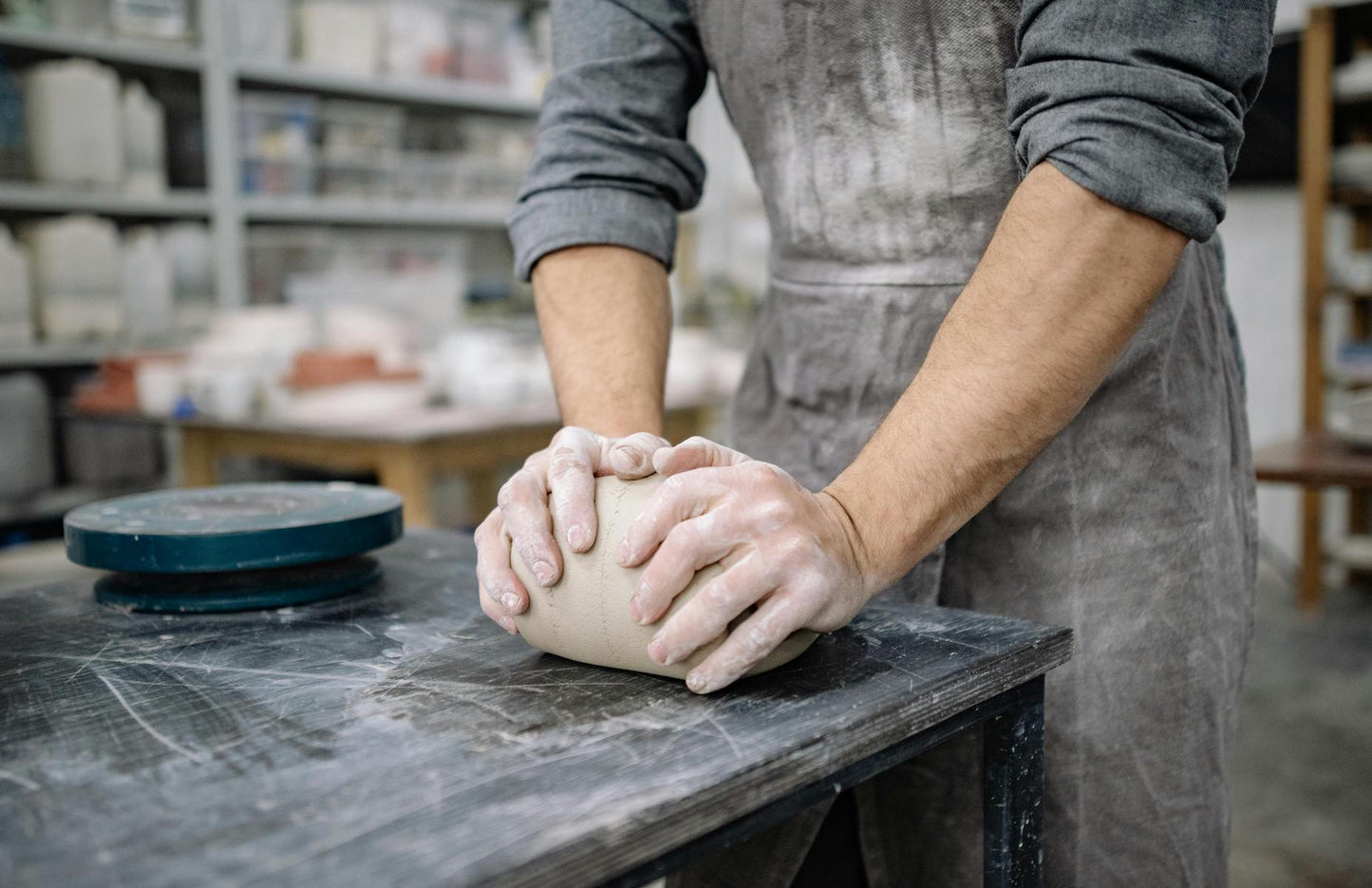 a potter works with clay in a pottery studio at Claya ceramics and pottery studio in Denver Colorado