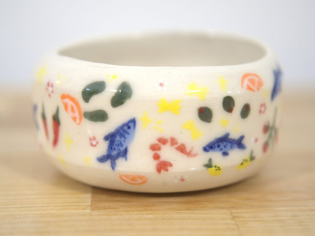 Hand-painted ceramic bowl with fish designs made at Claya in Denver