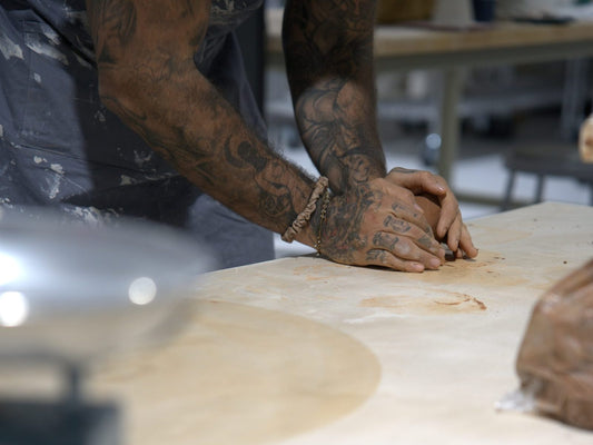 Wedging clay on a studio worktable at Claya pottery studio in RiNo, Denver