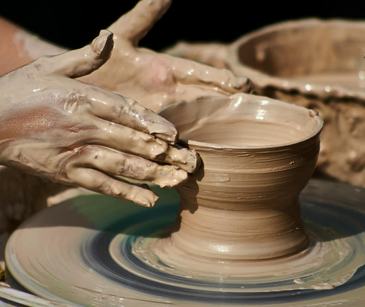 Close-up of hands forming clay on a pottery wheel