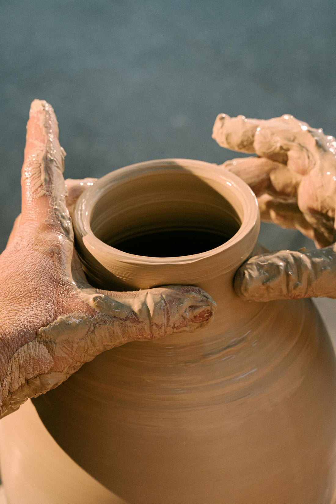 Beginner pottery student making a clay pot
