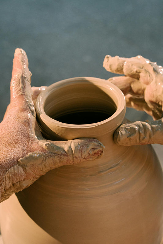 Beginner pottery student making a clay pot