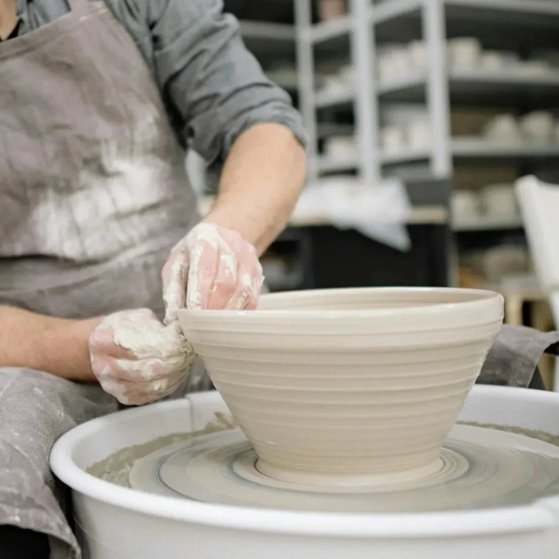 A potter throws a large bowl on the wheel at Claya in Denver