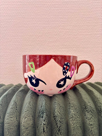 Face mug painted with underglaze, star eyes and hair clips