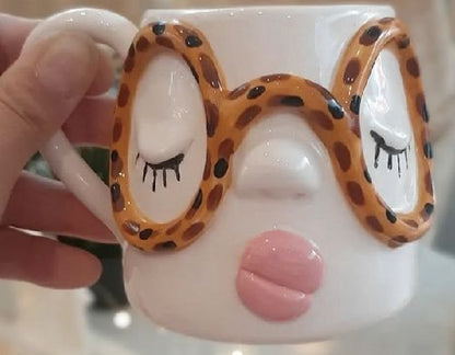 Close up of a face mug with leopard print glasses and sculpted lips