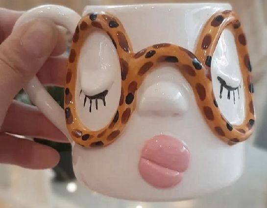 Close up of a face mug with leopard print glasses and sculpted lips