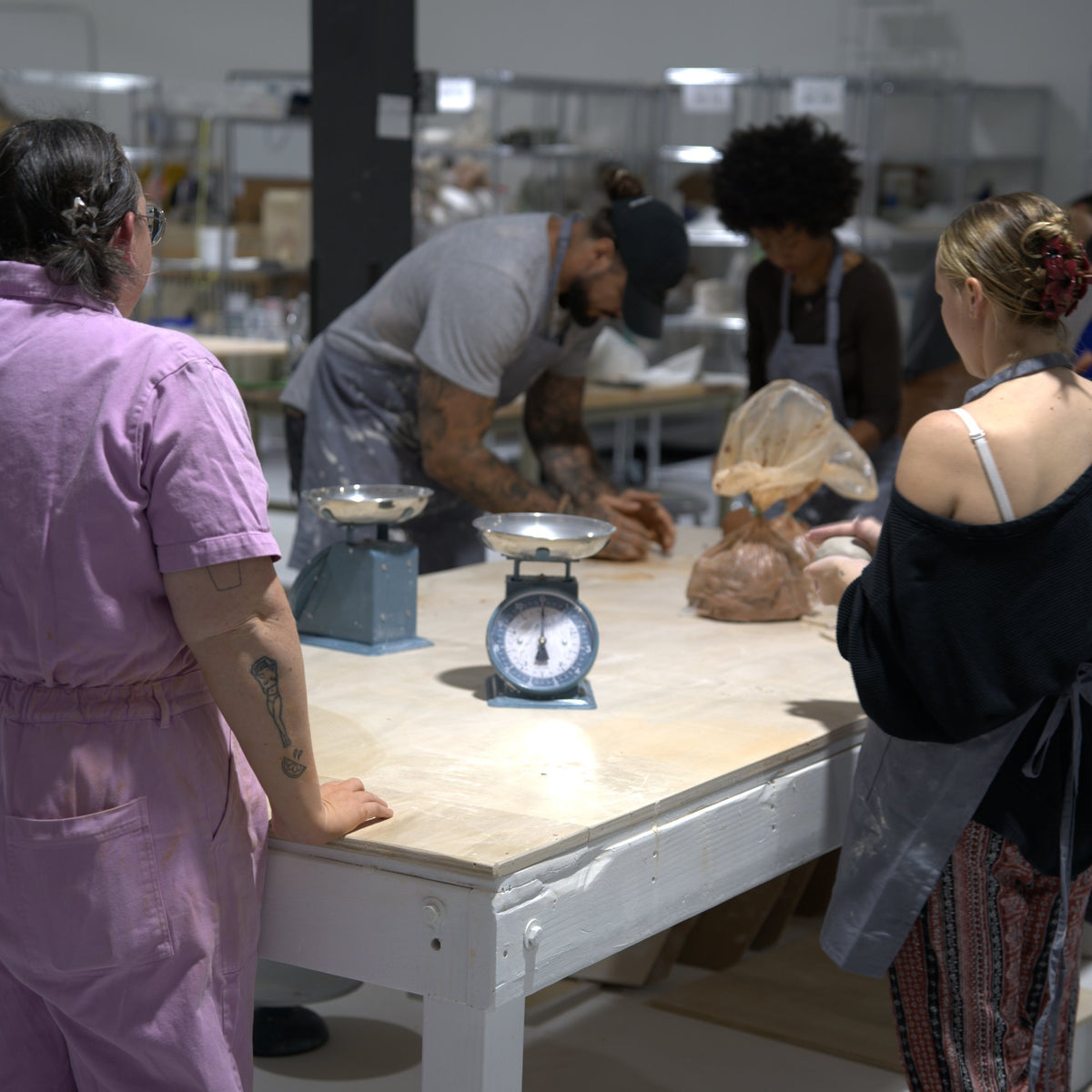 Instructor Caitlin with students weighing and wedging clay before a wheel class at Claya Studios in RiNo, Denver