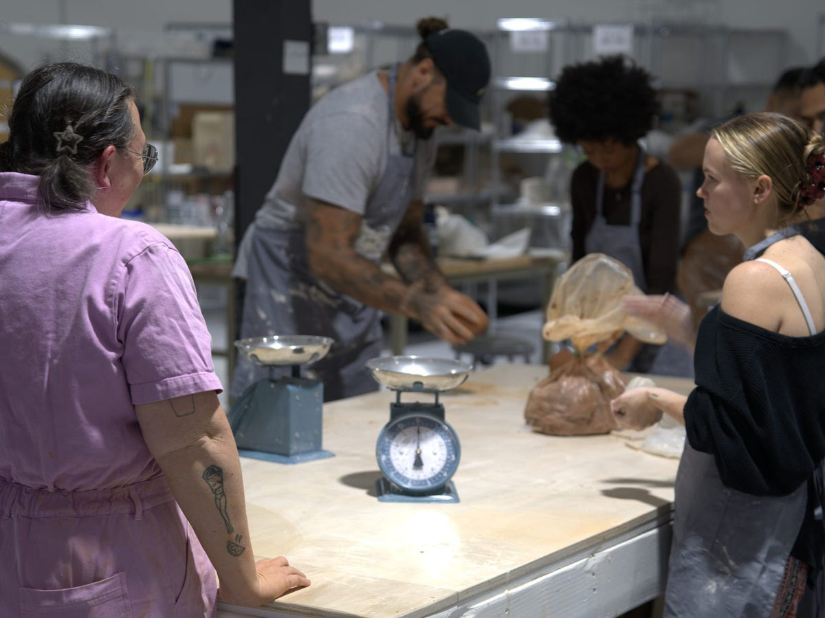 Instructor Caitlin with students at the wedging table during a class at Claya in RiNo, Denver