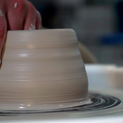 A wheel-thrown clay form spinning on the potter's wheel at Claya pottery studio in RiNo, Denver
