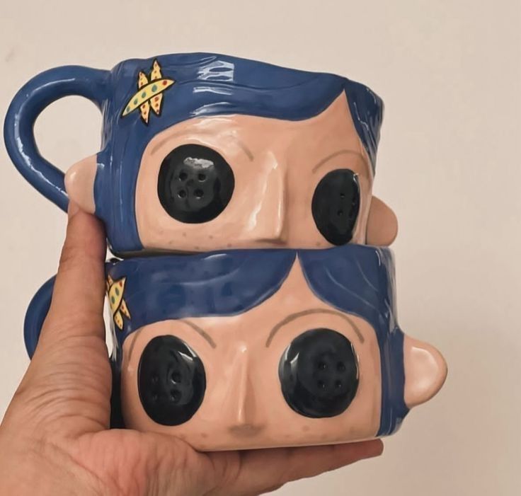 Handbuilt face mugs with sculpted features made in a Claya workshop