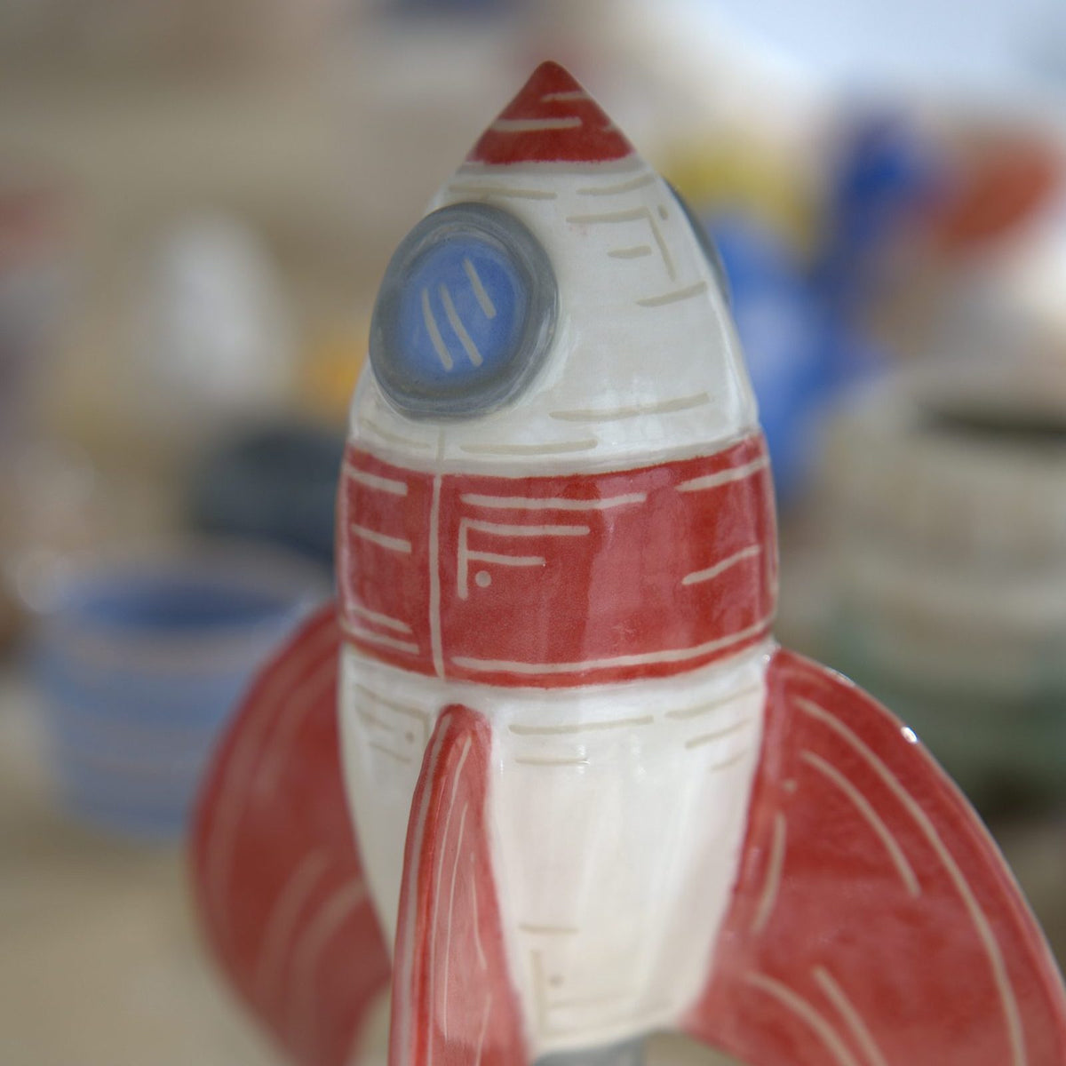 Hand-painted ceramic rocket sculpture made at Claya pottery studio in Denver