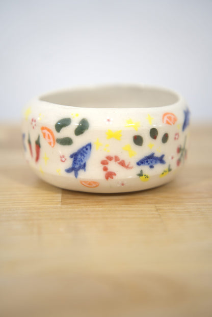Hand-painted ceramic bowl with fish and lemon designs made at Claya, RiNo Denver