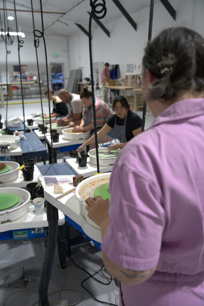 Beginner wheel throwing class at Claya Studios in RiNo, Denver, instructor Caitlin watching over students at their pottery wheels