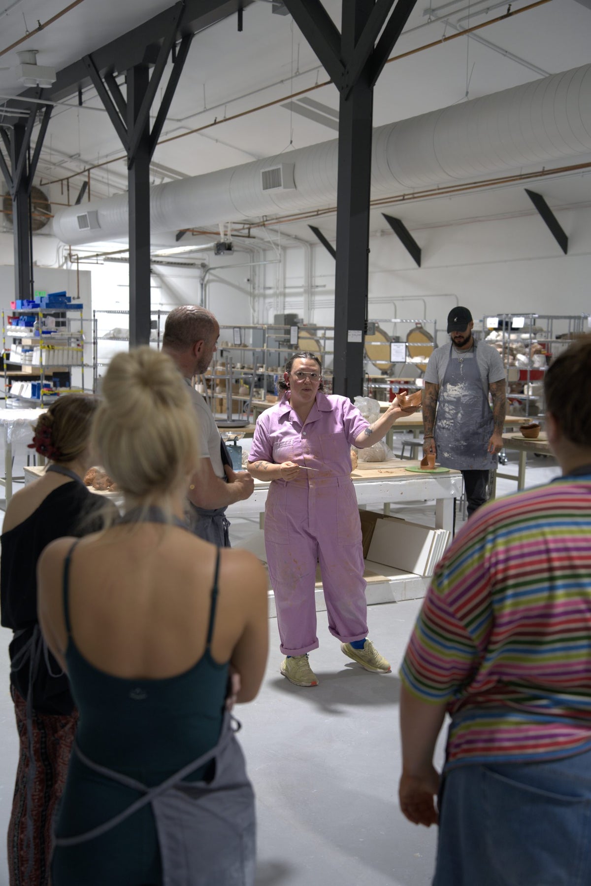 Beginner wheel throwing class at Claya Studios in RiNo, Denver, instructor Caitlin giving a demo to the class