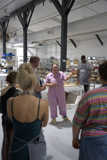 Beginner wheel throwing class at Claya Studios in RiNo, Denver, instructor Caitlin giving a demo to the class
