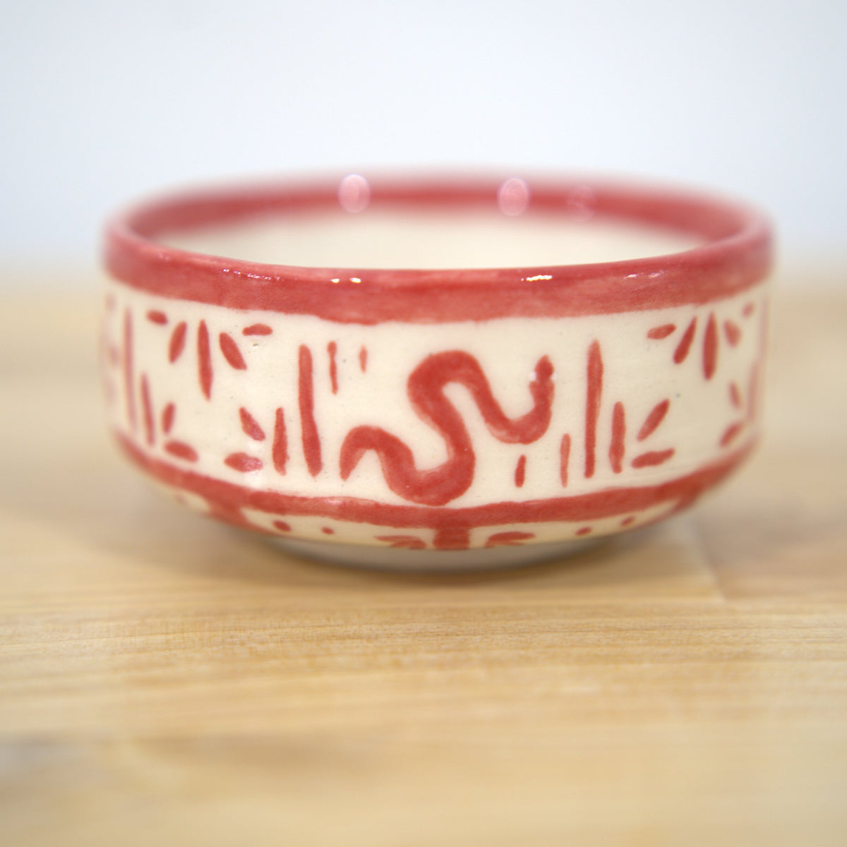 Red hand-painted ceramic bowl made at Claya Studios in RiNo, Denver