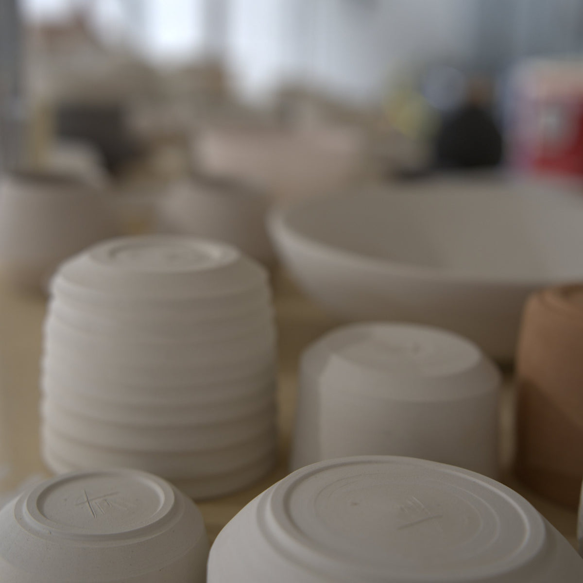 Stacked bisqueware bowls from wheel classes at Claya Studios in RiNo, Denver