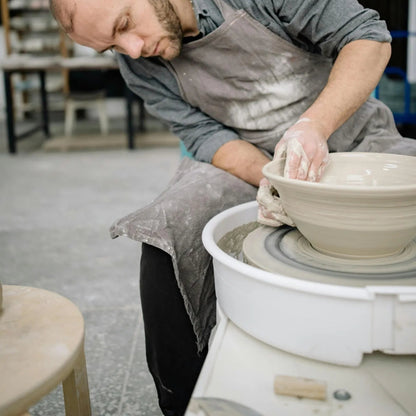 Potter at a pottery studio denver working on a pottery wheel in a studio at Denver Pottery Studio