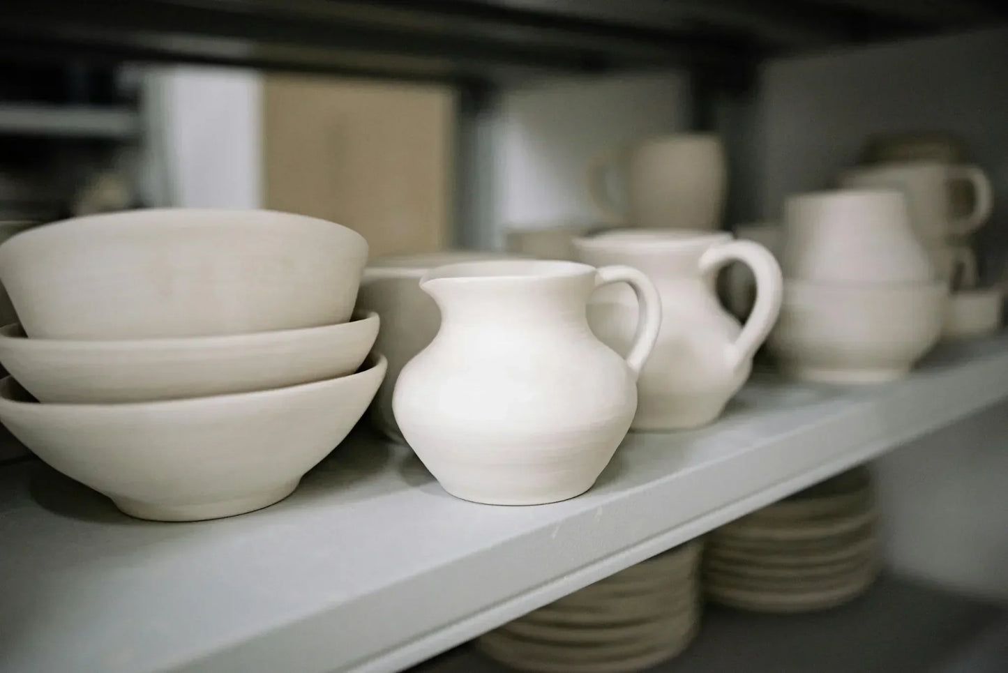 Finished student mugs and bowls from a Claya wheel class