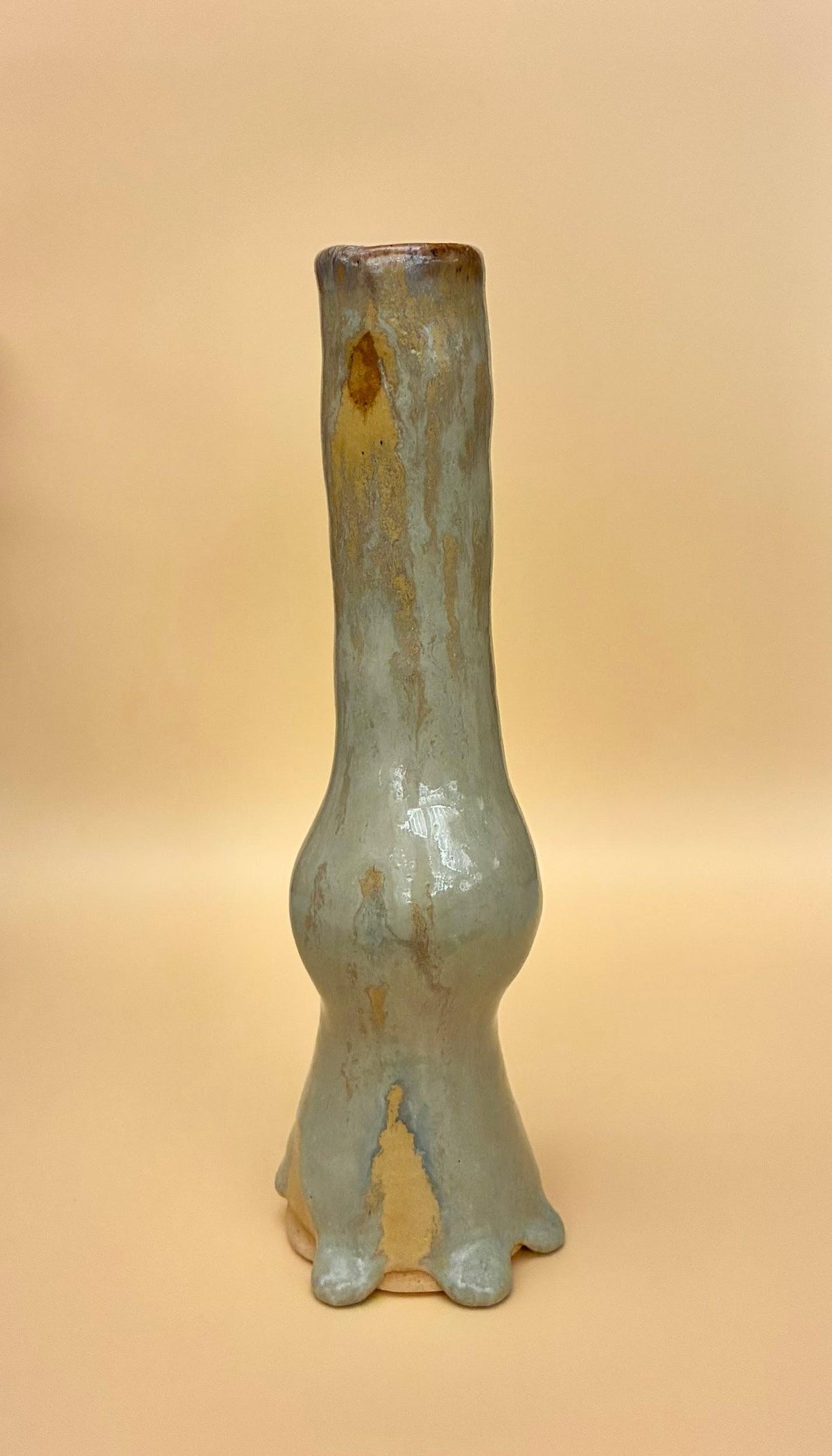 A handbuilt ceramic candlestick holder with a pale celadon glaze, made in Tess Chatfield's handbuilding workshop