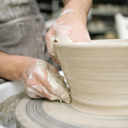 a student throws a bowl during beginners pottery class at Claya pottery studio in Denver, Colorado