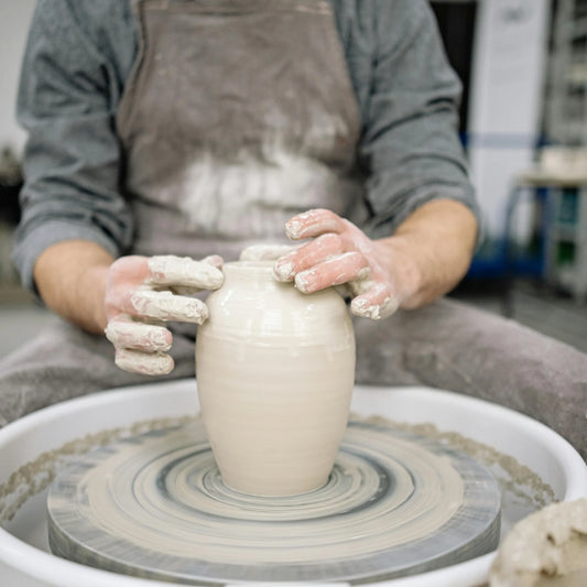 a potter forming a vase at Claya pottery studio during pottery class in Denver