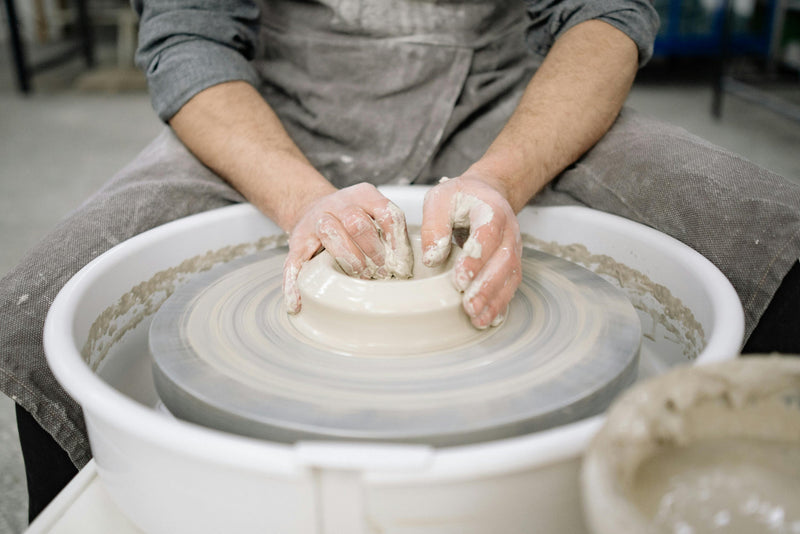 A Denver potter centers clay in a beginner pottery class on the throwing wheel at Claya