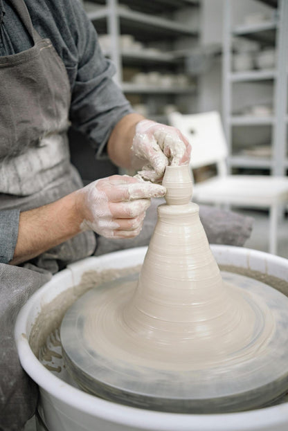 a potter throws a vase at claya pottery studio in denver