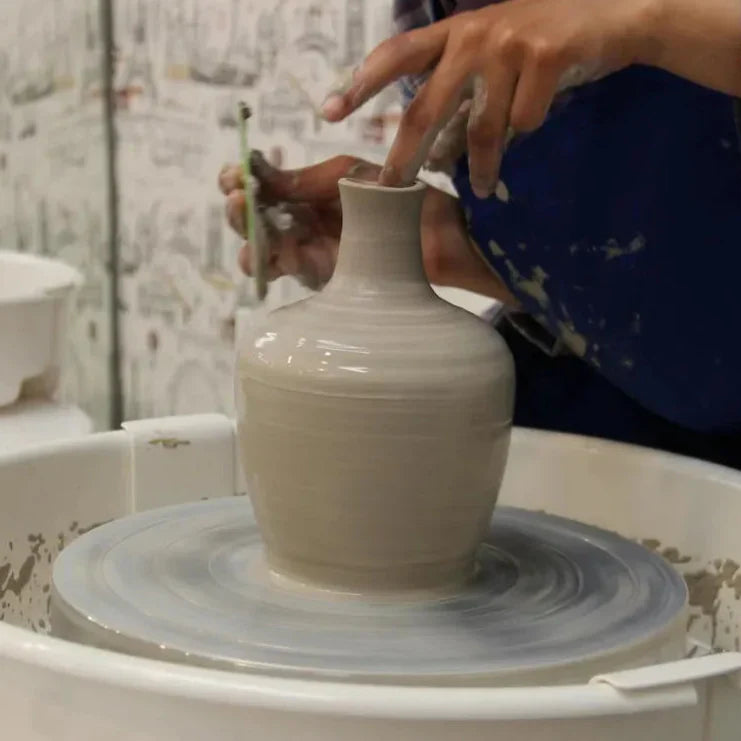 A student throws a vase during All Level Wheel Throwing class at Claya pottery studio in Denver